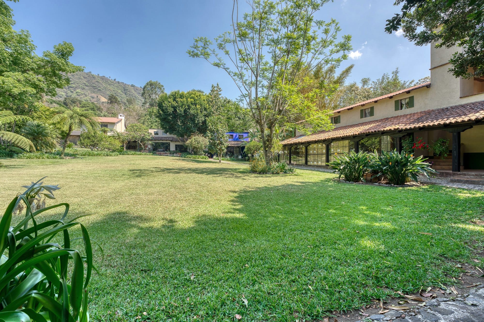 Wide lawn beside the main house veranda, suited to ceremonies and receptions